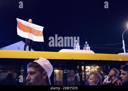 Auf dem Dach eines öffentlichen Busses mit einer alten belarussischen Flagge, Symbol des Widerstands gegen die Regierung, schreit ein Mann während einiger Proteste gegen die betrügerischen Präsidentschaftswahlen in Belarus am 9. August 2020 in Minsk, Weißrussland, am 11. August 2020 in Minsk, Weißrussland. (Foto von Celestino Arce/NurPhoto) Stockfoto