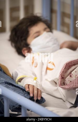Der 7-jährige iranische Junge, Mohammad Amin, der von der neuen Coronavirus-Krankheit infiziert ist, trägt am 6. September 2020 eine schützende Gesichtsmaske, als er auf einem Krankenhausbett im COVID-19-Abschnitt des Ali Asghar-Kinderkrankenhauses im Norden Teherans liegt. Die Iraner dachten, dass Kinder sich nicht mit dem COVID-19 infizieren würden, aber sie erkannten, dass Kinder jeden Alters mit der neuen Coronavirus-Krankheit infiziert werden, aber die meisten von ihnen, die infiziert sind, werden nicht so krank wie Erwachsene. (Foto von Morteza Nikoubazl/NurPhoto) Stockfoto