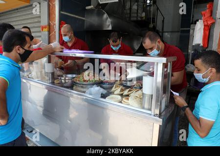 Palästinensische Männer, die Gesichtsschutzmasken tragen, stehen während sie am 07. September 2020 in einem Falafel-Restaurant inmitten der anhaltenden COVID-19-Pandemie des Coronavirus in Gaza-Stadt auf ihren Befehl warten. (Foto von Majdi Fathi/NurPhoto) Stockfoto