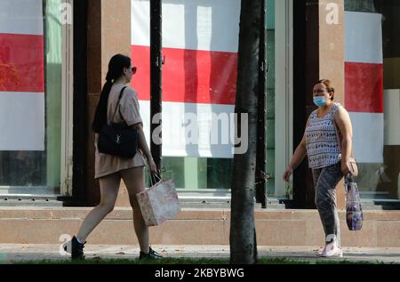 Am 7. September 2020 laufen Frauen an einem Laden in der Chreschtschatyk-Straße vorbei, an dem das Fenster mit der weißrussischen Nationalflagge bedeckt ist. (Foto von Sergii Chartschenko/NurPhoto) Stockfoto