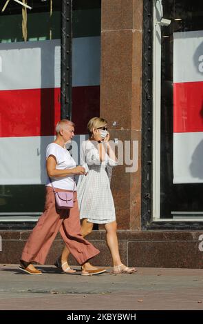 Am 7. September 2020 laufen Frauen an einem Laden in der Chreschtschatyk-Straße vorbei, an dem das Fenster mit der weißrussischen Nationalflagge bedeckt ist. (Foto von Sergii Chartschenko/NurPhoto) Stockfoto