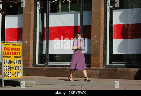 Frau mit Gesichtsmaske auf Spaziergängen an einem Laden in einer Straße in Chreschtschatyk vorbei, an dem das Fenster mit der weißrussischen Nationalflagge bedeckt ist, in Kiew, Ukraine, 7. September 2020. (Foto von Sergii Chartschenko/NurPhoto) Stockfoto