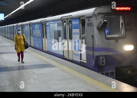 Eine Frau geht während eines Coronavirus-Notfalls in Kalkutta, Indien, am 09. September 2020 an Bord eines U-Bahn-Zuges. Ein Mann desinfiziert den Sitzbereich einer U-Bahn-Station während eines Coronavirus-Notfalls in Kalkutta, Indien, am 09. September 2020. Indiens Infektion mit dem Coronavirus stieg laut indischen Medienberichten auf 4,3 Millionen an. (Foto von Indranil Aditya/NurPhoto) Stockfoto