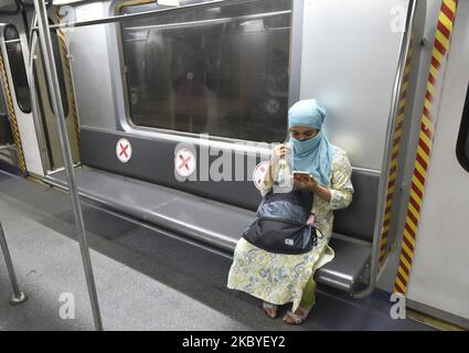Eine Frau sitzt während eines Coronavirus-Notfalls in Kalkutta, 09. September 2020, in einem Metrofach. Ein Mann desinfiziert den Sitzbereich einer U-Bahn-Station während eines Coronavirus-Notfalls in Kalkutta, Indien, am 09. September 2020. Indiens Infektion mit dem Coronavirus stieg laut indischen Medienberichten auf 4,3 Millionen an. (Foto von Indranil Aditya/NurPhoto) Stockfoto