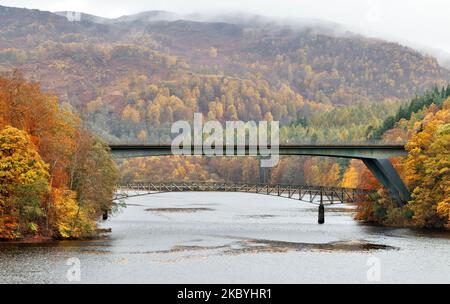Pitlochry Perthshire Schottland Loch Faskally A9 Straßenbrücke und Clunie Fußbrücke und Nebel über dem Hügel mit den Bäumen in herbstlichen Farben Stockfoto
