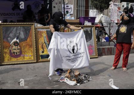 Mütter von Opfern von Frauenmorden und Vermissten, zerstörten und verbrannten eine Flagge und piñata der Figur des mexikanischen Präsidenten Andrés Manuel López Obrador, außerhalb der Nationalen Menschenrechtskommission, jetzt Casa Refugio Ni Una Menos. Am 11. September 2020 in Mexiko-Stadt, Mexiko. (Foto von Gerardo Vieyra/NurPhoto) Stockfoto