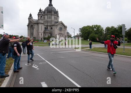 Die Teilnehmer im März tauschen sich mit einem Schwarzen aus, der vorbeigeht. 12. September 2020. Eine Gruppe von rund 200 Trump-Anhängern - viele von ihnen bewaffnet - marschierte zur Minnesota State Capital in St. Paul, MN, wo sie eine dreistündige Kundgebung abhielten. Redner verurteilten demokratische Politiker und die Black Lives Matter-Bewegung, kritisierten die Reaktion von Gouverneur Tim Walz auf die COVID-19-Pandemie, leugneten die Existenz von Rassismus und befürworteten die Wiederwahl Donald Trumps. Als sich die Demonstranten in die Hauptstadt machten, konfrontierte eine Gruppe von Gegendresten die Teilnehmer. Staatliche Patrouillenbeamte teilten die Gruppen auf Stockfoto