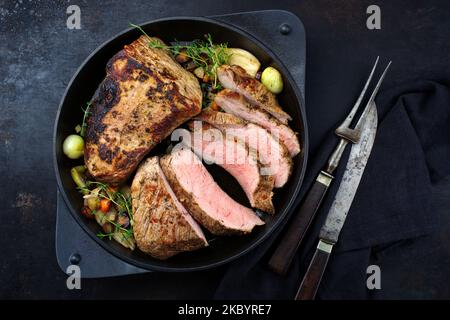 Tafelspitz Kalbsbraten mit Gemüse, Pilzen und Kräutern serviert mit dunkler Biersauce als Draufsicht in einem gusseisernen Topf Stockfoto