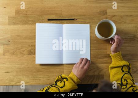 Leeres Notizbuch und Bleistift öffnen, Frau mit Tee in der Hand Stockfoto