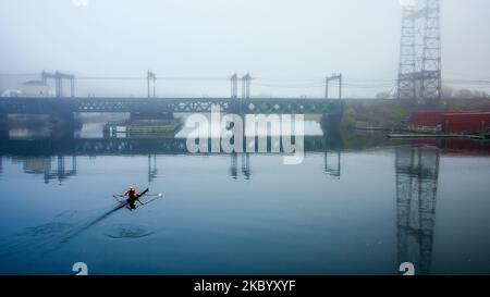 NORWALK, CT, USA - 4. NOVEMBER 2022: Schöner Nebel in der Stadt mit Ruderboot und Eisenbahnbrücke Stockfoto