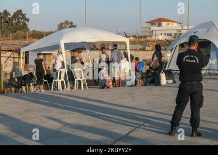 Familien von Migranten aus Afghanistan stehen Schlange, werden registriert, haben einen Coronavirus Covid-19 Schnelltest und betreten das neue Flüchtlingslager auf der Insel Lesbos, Griechenland, nach dem großen Brand, der das Moria Camp, das erste Aufnahme- und Registrierungslager auf der Insel komplett zerstört hat. Das neue Lager in der Nähe der Inselhauptstadt Mytilene in Mavrovouni oder Kara Tepe ist ein ehemaliger militärischer Schießplatz, aber Migranten sind skeptisch, einzureisen, da es sich im Moment um eine geschlossene Anlage handelt, die es ihnen nicht erlaubt, frei herumzulaufen, obwohl Nahrung, Zelte, Toiletten und m Stockfoto