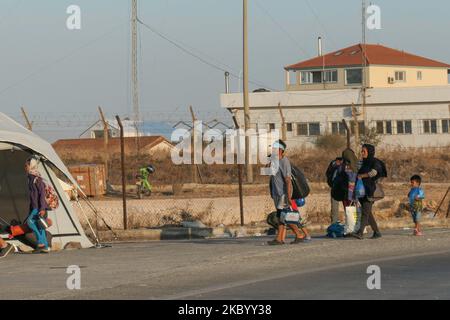 Familien von Migranten aus Afghanistan stehen Schlange, werden registriert, haben einen Coronavirus Covid-19 Schnelltest und betreten das neue Flüchtlingslager auf der Insel Lesbos, Griechenland, nach dem großen Brand, der das Moria Camp, das erste Aufnahme- und Registrierungslager auf der Insel komplett zerstört hat. Das neue Lager in der Nähe der Inselhauptstadt Mytilene in Mavrovouni oder Kara Tepe ist ein ehemaliger militärischer Schießplatz, aber Migranten sind skeptisch, einzureisen, da es sich im Moment um eine geschlossene Anlage handelt, die es ihnen nicht erlaubt, frei herumzulaufen, obwohl Nahrung, Zelte, Toiletten und m Stockfoto