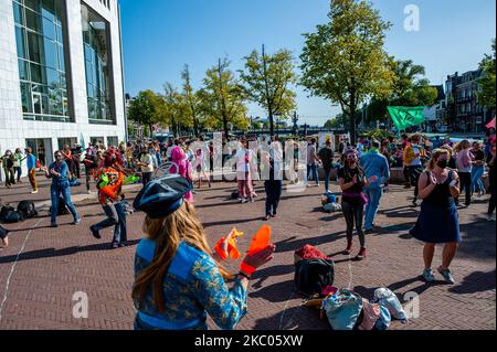 Demonstranten am 19.. September 2020 in Amsterdam, Niederlande. Den ganzen Monat lang hat die Klima-Aktivistengruppe Extinction Rebellion in den Niederlanden eine neue Kampagne mit dem Namen 'September Rebellion' geplant, um auf die Klima- und Umweltkrise aufmerksam zu machen. Auf dem Museumplein in Amsterdam tanzten Hunderte von XR-Aktivisten, um Maßnahmen gegen den Klimawandel zu fordern, was die Demonstranten als „zivile Disco-Bedienz“ bezeichneten. Aktivisten winkten Fahnen und tanzten zu Liedern, darunter dem 1977 erspielten Hit Stayin' Alive von Bee Gees. Nach dem Museumplein blockierten die Aktivisten für ein paar Minuten eine der meisten Stockfoto