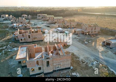 Luftaufnahme von neuen Häusern mit Backstein-Rahmenmauern im Bau in ländlichen Vorstadtbereich. Entwicklung von Immobilien in modernen Stadtvororten Stockfoto