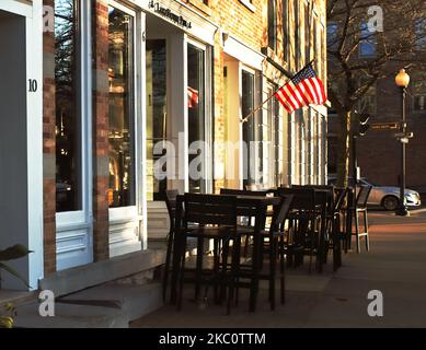 Skaneateles, New York, USA. 4. November 2022. Stühle und Tische vor einem Pub im Stadtzentrum von Skaneateles, NY, an einem wunderschönen Herbstmorgen Stockfoto