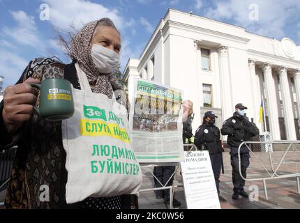 Eine ältere Frau, die eine schützende Gesichtsmaske trägt, hält am 29. September 2020 Symbole der Volksdienerin („Sluga Narodu“) der politischen Partei des ukrainischen Präsidenten Wolodymyr Zelenski in der Nähe des ukrainischen Parlaments in Kiew, Ukraine. Am 29. September wurden in der Ukraine 3 627 neue COVID-19-Coronavirus-Fälle bestätigt. Insgesamt wurden in der Ukraine 204 932 COVID-19 Coronavirus-Fälle offiziell bestätigt, 90 250 Menschen wurden geborgen und 4 065 Menschen starben. (Foto von STR/NurPhoto) Stockfoto