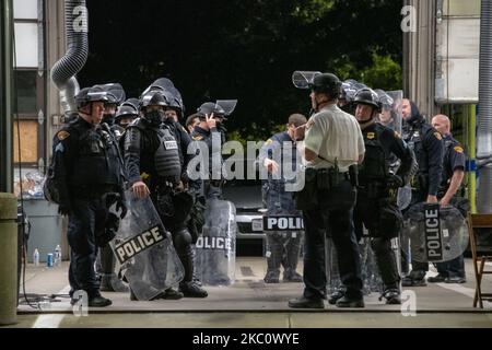 Die Bereitschaftspolizei erhält Befehle aus einer Feuerwache. Mehrere Hundert Demonstranten aus Black Lives Matter versammelten sich am 29. September 2020 vor der ersten Präsidentschaftsdebatte in Cleveland, Ohio. Demonstranten marschierten für einen kurzen marsch durch die Case Western Reserve University, bevor sie sich aufspalten, wo sich später ein kleinerer Protest außerhalb der Cleveland Clinic bildete, wo die Debatte stattfand. Die Polizeipräsenz war bemerkenswert, da die Polizisten in Bereitschaftstrikot gekleidet waren. Die Nationalgarde war ebenfalls anwesend und stellte zusätzliche Sicherheit bereit. Die Demonstranten blieben die ganze Nacht über friedlich. (Foto von Adam J. Dewey/NurPhoto) Stockfoto