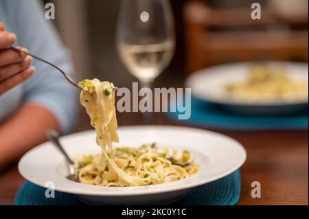 Die weibliche Hand hält die Meeresfrüchte fettuccine Pasta mit der Gabel, Nahaufnahme Stockfoto