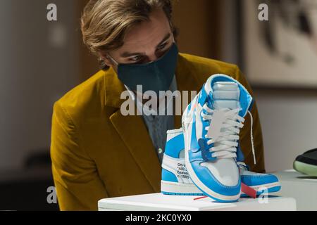 Ein Mitarbeiter der Galerie sieht sich Ein Paar von einem cremefarbenen X Nike Air Jordan 1 UNC „Revealing“, 2018, (geschätzter Verkaufspreis £2.000 - 2.200) während eines Fotoanrufs für Bonhams' Pop x Culture-Verkauf am 01. Oktober 2020 in London, England, an. (Foto von Wiktor Szymanowicz/NurPhoto) Stockfoto