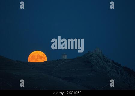 Erntemon, der am 1. Oktober 2020 hinter dem Schloss Rocca Calascio, Abruzzen, Italien, leuchtet. In diesem Monat wird es zwei Vollmonde geben: Der zweite (Blauer Mond) wird am 31. Oktober leuchten. (Foto von Lorenzo Di Cola/NurPhoto) Stockfoto