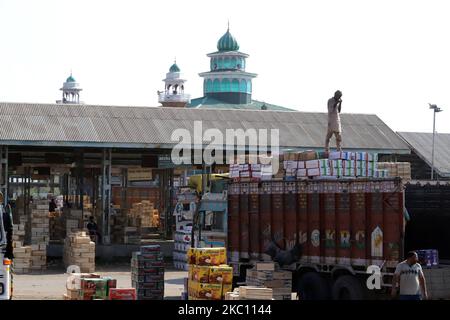 Kashmiri-Arbeiter transportieren am 02. Oktober 2020 Kartons mit Produkten, die auf Lastwagen auf einem großen Obstmarkt in Sovore, District Baramulla, Jammu und Kashmir, Indien, etwa 54kms nördlich von Srinagar, verladen werden. Vor kurzem, die Apple-Züchter und Käufer bei Fruit Mandi in Sopore Bereich des nördlichen Kaschmir Baramulla Bezirk inszenierte einen Protest gegen die Regierung für â € œfailingâ €, um ihre Probleme zu beheben. (Foto von Nasir Kachroo/NurPhoto) Stockfoto