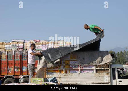 Kashmiri-Arbeiter transportieren am 02. Oktober 2020 Kartons mit Produkten, die auf Lastwagen auf einem großen Obstmarkt in Sovore, District Baramulla, Jammu und Kashmir, Indien, etwa 54kms nördlich von Srinagar, verladen werden. Vor kurzem, die Apple-Züchter und Käufer bei Fruit Mandi in Sopore Bereich des nördlichen Kaschmir Baramulla Bezirk inszenierte einen Protest gegen die Regierung für â € œfailingâ €, um ihre Probleme zu beheben. (Foto von Nasir Kachroo/NurPhoto) Stockfoto