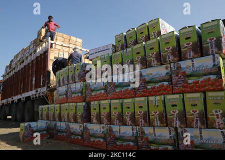 Kashmiri-Arbeiter transportieren am 02. Oktober 2020 Kartons mit Produkten, die auf Lastwagen auf einem großen Obstmarkt in Sovore, District Baramulla, Jammu und Kashmir, Indien, etwa 54kms nördlich von Srinagar, verladen werden. Vor kurzem, die Apple-Züchter und Käufer bei Fruit Mandi in Sopore Bereich des nördlichen Kaschmir Baramulla Bezirk inszenierte einen Protest gegen die Regierung für â € œfailingâ €, um ihre Probleme zu beheben. (Foto von Nasir Kachroo/NurPhoto) Stockfoto