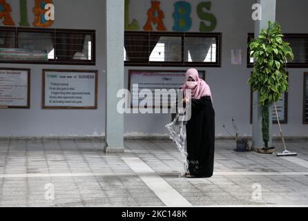 Ein palästinensischer Arbeiter, der eine Gesichtsmaske trägt, desinfiziert eine Schule vor Beginn eines neuen akademischen Jahres, angesichts der Besorgnis über die Ausbreitung des COVID-19 in Khan Younis im südlichen Gazastreifen am 4. Oktober 2020. (Foto von Majdi Fathi/NurPhoto) Stockfoto