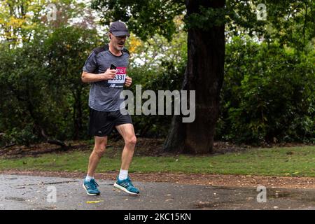 Tim Jackson, ein Teilnehmer des Virgin Money Virtual London Marathon, wird am 4. Oktober 2020 bei kaltem Regenwetter im Dulwich Park in South London, England, laufen sehen. Aufgrund der Covid-19-Pandemie war der London Marathon für die Öffentlichkeit virtuell. Die Teilnehmer laufen an Orten der Wahl und verfügen über eine mobile Anwendung als Überwachungssystem. Familie und Freunde nahmen oft kürzere Distanzen ein, um den Läufer zu unterstützen. (Foto von Dominika Zarzycka/NurPhoto) Stockfoto