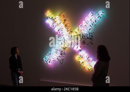 Mitarbeiter der Galerie stehen neben „Human Nature Knows/doesn’t Know“ 1983/86 des amerikanischen Künstlers Bruce Nauman während einer Fotoausstellung, um die erste neue Ausstellung in der Tate Modern seit der Wiedereröffnung der Galerie in diesem Sommer am 05. Oktober 2020 in London, England, zu bewerben. Die Ausstellung wird als erste Bruce Naumans umfassende Arbeit in London seit mehr als 20 Jahren zeigen, die eine Reihe von Medien umfasst, darunter Skulpturen, Sound, Film, Video und Neonarbeiten. (Foto von Wiktor Szymanowicz/NurPhoto) Stockfoto