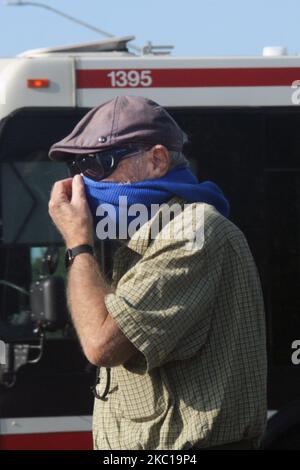 Ein Mann bedeckt sein Gesicht mit einem Schal, um ihn vor dem neuartigen Coronavirus (COVID-19) zu schützen, als er sich am 21. September 2020 in Toronto, Ontario, Kanada, an Bord eines öffentlichen Busses vorbereitete. (Foto von Creative Touch Imaging Ltd./NurPhoto) Stockfoto