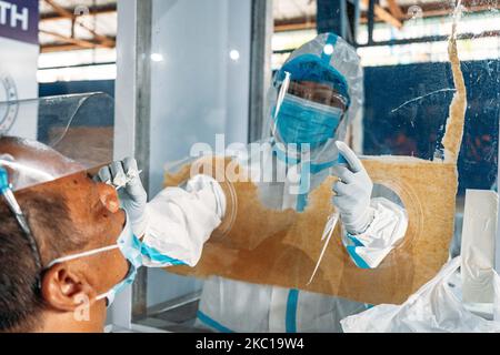 Ein Mitarbeiter im Gesundheitswesen führt bei einem abgedeckten Gericht in Baseco, Metro Manila, Philippinen, einen Abstrichtest zur Coronavirus-Krankheit (COVID-19) durch, der am 6. Oktober 2020 durchgeführt wurde. Der Bürgermeister von Manila, Francisco „Isko Moreno“ Domagoso, sagte, dies sei Teil der Bemühungen der Stadtregierung zur Bekämpfung der Coronavirus-Krankheit (COVID-19). (Foto von Mohd Sarajean/NurPhoto) Stockfoto