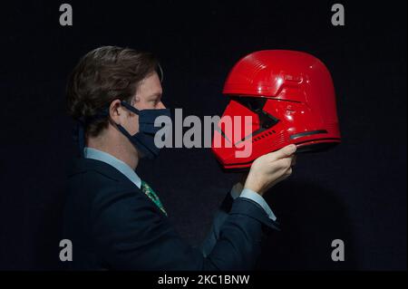 Ein Mitarbeiter posiert mit Sith-Trooper-Helm, der in Star Wars: The Rise of Skywalker (2019) verwendet wird, Schätzung: £20.000-30.000 während des Fotoaufrufs für den Verkauf von Bonhams Entertainment-Erinnerungsstücken am 08. Oktober 2020 in London, England. (Foto von Wiktor Szymanowicz/NurPhoto) Stockfoto