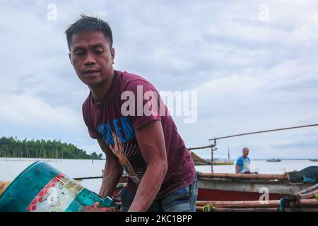 Eine Gruppe von Männern in Binangonan, Rizal, erntete heute, am 8. Oktober 2020, in Laguna Bay eine kleine Süßwasser-Muschel, die in Pampanga geliefert werden soll. Süßwasser-Schnecken werden häufig als Futter für Enten verwendet. Die Erntemaschinen sagten, dass der Preis für einen Sack Süßwasser-Muscheln nur 18 Pesos beträgt. (Foto von Ryan Eduard Benaid/NurPhoto) Stockfoto