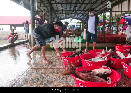 Eine Gruppe von Fischporteuren in Binangonan, Rizal, entladen das Becken voller Fische im Fischhafen heute Nachmittag des 8. Oktober 2020 von Fischteichen in Laguna De Bay, Indonesien. (Foto von Ryan Eduard Benaid/NurPhoto) Stockfoto