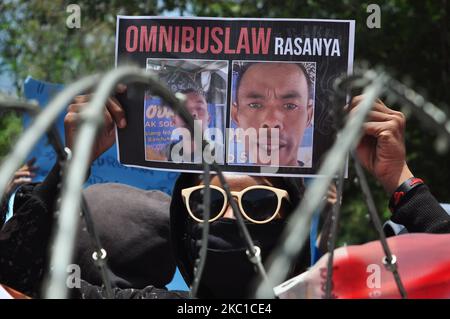 Ein Demonstrator hält ein Plakat mit einer Protestdemonstration vor dem regionalen Legislativbüro, Jalan Samratulangi, Palu City, Zentral-Sulawesi, Indonesien, Donnerstag, 8. Oktober 2020. Demonstration von Studenten vor Ort, nachdem die Legislative Indonesien ein neues Gesetz über die Schaffung von Arbeitsplätzen ausgestellt hat. (Foto von Faldi Muhammad/NurPhoto) Stockfoto