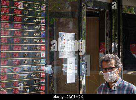Ein Iraner schaut zu, als er am 10. Oktober 2020 an einer Wechselstube im Geschäftsviertel von Teheran vorbeigeht. Der US-Dollar ist wieder gestiegen. Sie können den Preis unter 300.000 IRR für jeden Dollar auf dem elektronischen Brett sehen, das in den Wechselstummeln angezeigt wird, aber der reale USD-Preis betrug 300.000 IRR für den Kauf und 3.250.000 IRR für den Verkauf auf jedem Dollar, teilte Ein Straßengeldwechsler dem Fotografen mit. (Foto von Morteza Nikoubazl/NurPhoto) Stockfoto