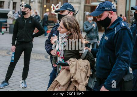 Die polnische Polizei verhaftet eine Frau während einer Anti-Gesichtsmaske-Protestierenden in Breslau, Polen am 10. Oktober 2020. Die Demonstranten erkennen an, dass es kein Virus gibt und dass es sich um eine Verschwörung großer Unternehmen handelt. (Foto von Krzysztof Zatycki/NurPhoto) Stockfoto