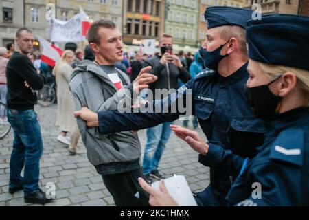 Die polnische Polizei verhafte einen Mann während einer Anti-Gesichtsmaske-Protestierenden in Breslau, Polen, am 10. Oktober 2020. Die Demonstranten erkennen an, dass es kein Virus gibt und dass es sich um eine Verschwörung großer Unternehmen handelt. (Foto von Krzysztof Zatycki/NurPhoto) Stockfoto