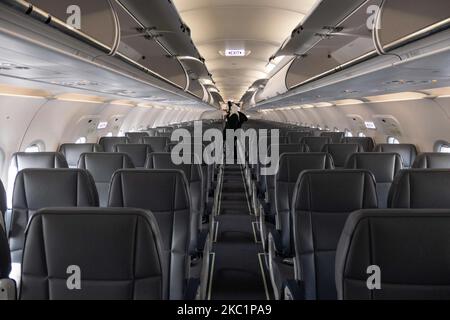 Das Innere der Kabine nach der Landung mit leeren Sitzen. Fliegen mit einem Flugzeug des Typs Lauda Airbus A320 mit der Registrierung 9H-LMJ während der Coronavirus-Pandemie Covid-19 mit Passagier- und Crew-Personal im Gesichtsschutz. Laudamotion oder Lauda ist eine österreichische Low-Cost-Fluggesellschaft, die Ryanair gehört und die Ryanair-Codes FR für IATA, RYR für ICAO und RYANAIR-Rufzeichen verwendet. Die Billigfluggesellschaft hat ihren Sitz am Vienna International Airport VIE LOWW oder am Flughafen Wien-Schwechat in Österreich mit einer Flotte von 28 Airbus-Flugzeugen. Wien, Österreich am 12. Oktober 2020 (Foto von Nicolas Economou/NurPhoto) Stockfoto