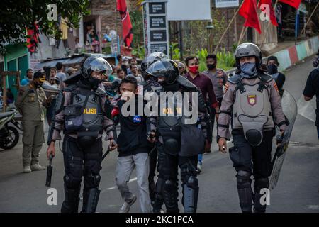 Polizeibeamte der Bereitschaftspolizei verhaften einen Protestierenden, der am 13. Oktober 2020 bei einer Protestkundgebung gegen das Omnibus-Gesetz in Magelang, Zentraljava, Indonesien, für Unruhen sorgte. Massenproteste gegen die Arbeitsreformen der Regierung in einem Gesetz zur Schaffung von Arbeitsplätzen, die befürchten, dass Investoren auf Kosten der Arbeitsrechte und der Umwelt begünstigt werden. (Foto von Rizqullah Hamiid/NurPhoto) Stockfoto