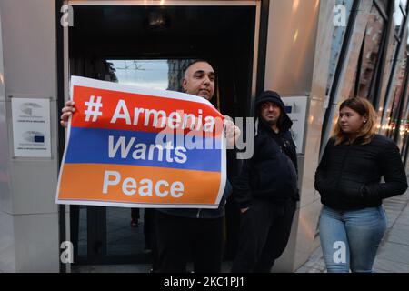 Ein Protestler hält ein Plakat mit der Aufschrift „Armenien will Frieden“ am Eingang des Gebäudes der Europäischen Kommission in Sofia. Mitglieder der armenischen Diaspora versammelten sich im Zentrum von Sofia zu einer friedlichen Demonstration, um gegen die bewaffneten Auseinandersetzungen zwischen aserbaidschanischer und armenischer Seite in der umstrittenen Region Berg-Karabach zu protestieren und um Hilfe zur Beendigung des Terrorismus und der aserbaidschanischen Gewalt zu fordern. Am Montag, den 12. Oktober 2020, in Sofia, Bulgarien. (Foto von Artur Widak/NurPhoto) Stockfoto