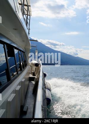 Eine schöne Aussicht vom Deck eines weißen Schiffes von Malcesine am Gardasee mit den italienischen Alpen im Hintergrund, Lombardei, Norditalien Stockfoto