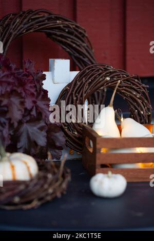 Herbstdekorationen mit Kürbissen, Lichtern und Kränzen. Dekoration auf der Veranda. Stockfoto