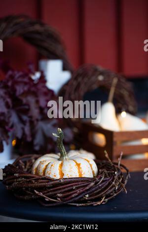 Herbstdekorationen mit Kürbissen, Lichtern und Kränzen. Dekoration auf der Veranda. Stockfoto