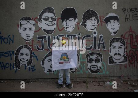 Eine Person hält eine Flagge mit einem -A- in Bezug auf -APRUEBO- (Approve). Direkt vor einem Wandbild mit Fotos der tödlichen Opfer von Polizeimissbrauch während des sozialen Ausbruchs, mit dem Wort JUSTICIA (Gerechtigkeit) im Zentrum. Zwei Wochen nach der Volksabstimmung, eine neue politische Verfassung in Chile abzulehnen oder anzunehmen, inmitten der Demonstration und des Protests gegen die Regierung von Sebastián Piñera, soziale Ungleichheit und das neoliberale System. Am 16. Oktober 2020 in Santiago de Chile, Chile. (Foto von Claudio Abarca Sandoval/NurPhoto) Stockfoto