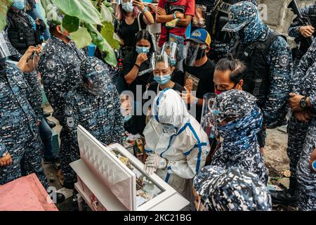 Die politische Gefangene Reina Mae Nasino, die vollständige Schutzausrüstung und Handschellen trägt, sagt auf dem Nordfriedhof von Manila, Philippinen, am 16. Oktober 2020, dass sie ihr letztes Auf Wiedersehen zu ihrem drei Monate alten Baby River gebracht hat. (Foto von Mohd Sarajean/NurPhoto) Stockfoto