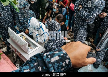 Die politische Gefangene Reina Mae Nasino, die vollständige Schutzausrüstung und Handschellen trägt, sagt auf dem Nordfriedhof von Manila, Philippinen, am 16. Oktober 2020, dass sie ihr letztes Auf Wiedersehen zu ihrem drei Monate alten Baby River gebracht hat. (Foto von Mohd Sarajean/NurPhoto) Stockfoto