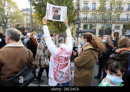 Eine Frau mit blutbefleckter Bluse hält eine Kopie der satirischen Zeitung Charlie Hebdoas People Gathere on Place de la Republique in Paris am 18. Oktober 2020, zwei Tage nachdem er von einem Angreifer, der von Polizisten getötet wurde, geköpft wurde. Tausende von Menschen versammeln sich am 18. Oktober in Paris und anderen französischen Städten in einer Solidaritäts- und Trotzkundgebung, nachdem ein Lehrer enthauptet wurde, weil er den Schülern Karikaturen des Propheten Mohammed gezeigt hatte. Sein Mord in einem Pariser Vorort am 16. Oktober schockierte das Land und brachte Erinnerungen an eine Welle islamistischer Gewalt im Jahr 2015 zurück. (Foto von Michel Stoupak/NurPhoto) Stockfoto