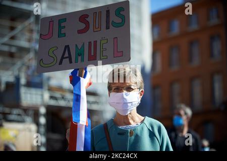 Eine Frau hält ein Plakat mit der Aufschrift „Ich bin Samuel“ mit einem Band in den französischen Farben. Nach der Tötung von Samuel Paty, Lehrer für Geographie-Geschichte, in Conflans-Sainte-Honorine (Yvelines) am 16.. Oktober versammelten sich mehrere Tausende von Menschen auf dem Hauptplatz von Toulouse, vor dem Rathaus, dem Capitole, um die Meinungsfreiheit zu verteidigen und Samuel zu ehren. Einige Leute kamen mit einem Cover von Charlie Hebdo, da der Lehrer getötet wurde, nachdem er seinen Schülern die Karikaturen von Charlie Hebdo von Muhammed gezeigt hatte. Der Mörder wurde anschließend von der französischen Polizei getötet. Am 18.. Oktober 2020 i Stockfoto